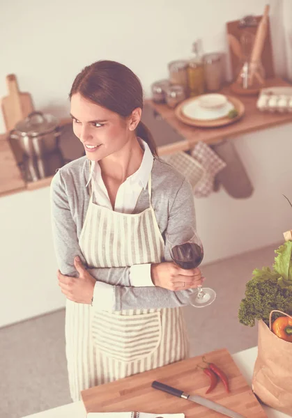 Mooie vrouw die thuis wat wijn drinkt in de keuken — Stockfoto