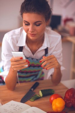 Kadın mutfakta salata hazırlıyor.