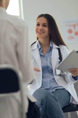 Doktor ve hasta masada otururken bir şey tartışıyorlar. İlaç ve sağlık hizmetleri kavramı