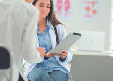 Doktor ve hasta masada otururken bir şey tartışıyorlar. İlaç ve sağlık hizmetleri kavramı