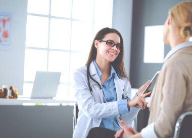 Doktor ve hasta masada otururken bir şey tartışıyorlar. İlaç ve sağlık hizmetleri kavramı