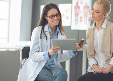 Doktor ve hasta masada otururken bir şey tartışıyorlar. İlaç ve sağlık hizmetleri kavramı