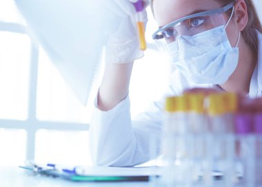 Modern laboratuvar veya hastanede plastik tıbbi tüplerle çalışan araştırmacı, doktor, bilim adamı veya laboratuvar asistanı.