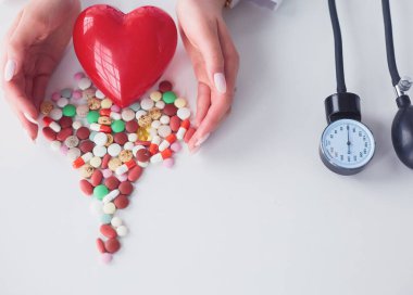 Masada kırmızı kalbi ve steteskopu olan kardiyolog.