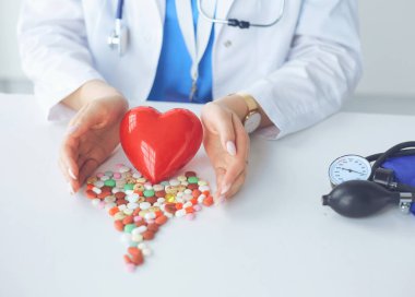 Masada kırmızı kalbi ve steteskopu olan kardiyolog.