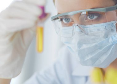 Modern laboratuvar veya hastanede plastik tıbbi tüplerle çalışan araştırmacı, doktor, bilim adamı veya laboratuvar asistanı