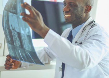 Genç Afrikalı doktor portresi hastaların röntgenlerini tutuyor.