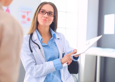 Doktor ve hasta masada otururken bir şey tartışıyorlar. İlaç ve sağlık hizmetleri kavramı