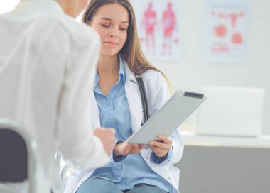 Doktor ve hasta masada otururken bir şey tartışıyorlar. İlaç ve sağlık hizmetleri kavramı