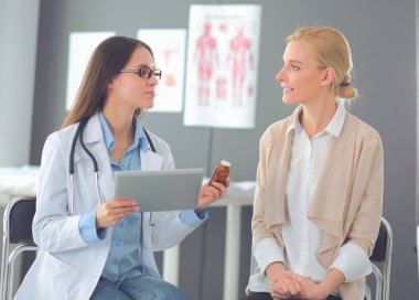 Doktor ve hasta masada otururken bir şey tartışıyorlar. İlaç ve sağlık hizmetleri kavramı
