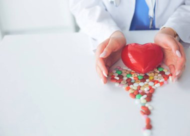 Masada kırmızı kalbi ve steteskopu olan kardiyolog.