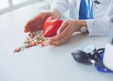 Masada kırmızı kalbi ve steteskopu olan kardiyolog.