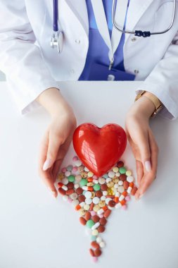 Masada kırmızı kalbi ve steteskopu olan kardiyolog.