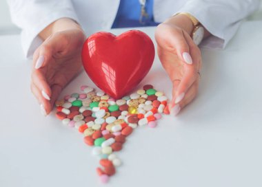 Masada kırmızı kalbi ve steteskopu olan kardiyolog.