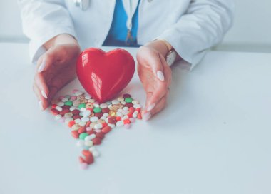 Masada kırmızı kalbi ve steteskopu olan kardiyolog.