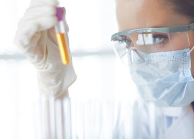 Modern laboratuvar veya hastanede plastik tıbbi tüplerle çalışan araştırmacı, doktor, bilim adamı veya laboratuvar asistanı