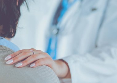 Kadın doktor bir hastaya danışmanlık yapıyor ve tıbbi bilgi ve teşhisi açıklıyor.