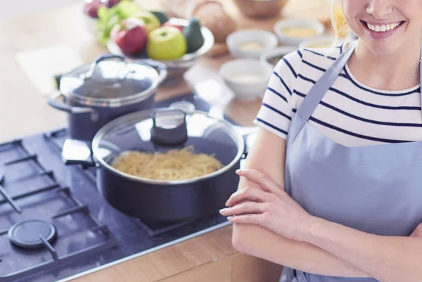 Junge Frau steht neben Schreibtisch in der Küche — Stockfoto