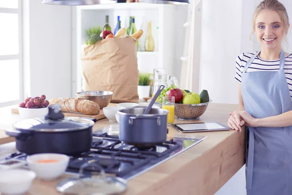 Schöne junge Frau kocht zu Hause in der Küche — Stockfoto
