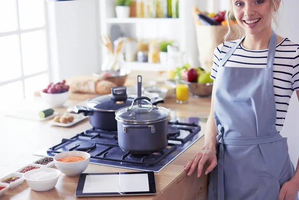 Mooie jonge vrouw koken in keuken thuis — Stockfoto