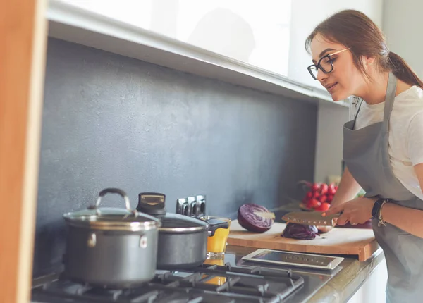 タブレットを使って台所で料理をする若い女性 — ストック写真