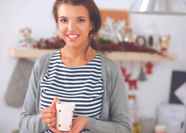 Mutfak arka planında fincanı olan genç bir kadının portresi.. — Stok fotoğraf