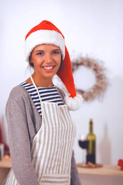 幸せな若い女性笑顔幸せを持って楽しみますクリスマスの準備を身に着けているサンタの帽子 — ストック写真