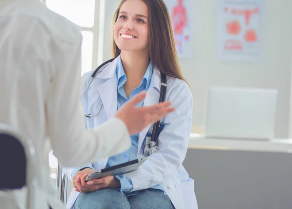 Doctor y paciente discutiendo algo mientras están sentados en la mesa. Concepto de medicina y salud — Foto de Stock