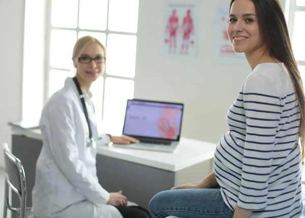 Hermosa mujer embarazada sonriente con el médico en el hospital — Foto de Stock