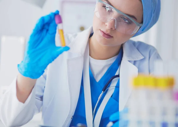 Asistente de laboratorio mujer analizando una muestra de sangre —  Fotos de Stock