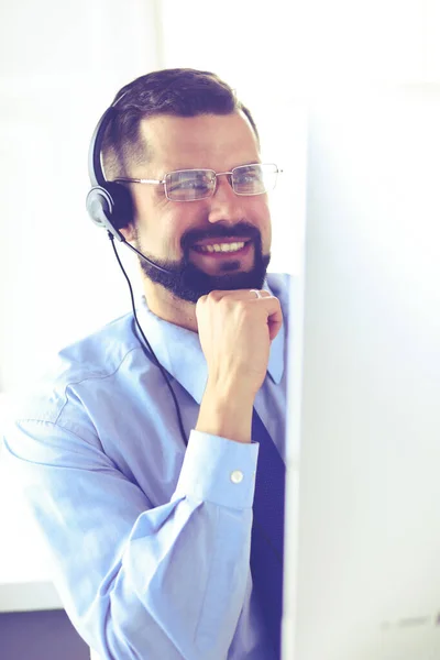 Ritratto di un giovane con un auricolare davanti a un computer portatile — Foto Stock