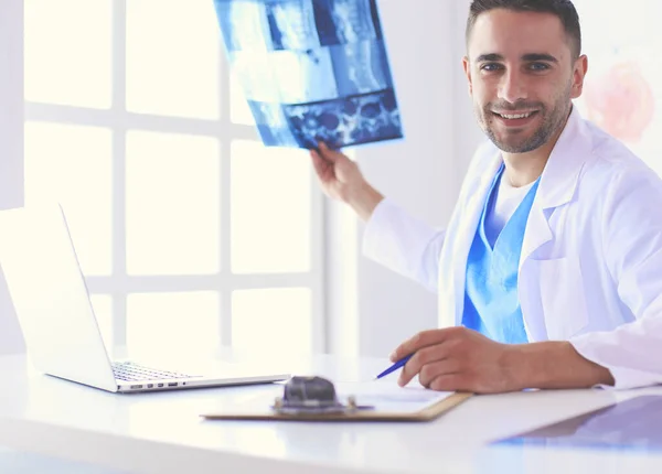 Schöner Arzt spricht mit junger Patientin und macht sich Notizen, während er in seinem Büro sitzt. — Stockfoto