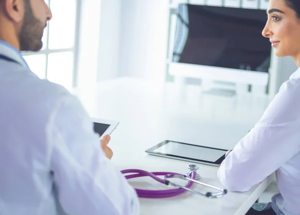 Ärzteteam sitzt und diskutiert am Tisch — Stockfoto