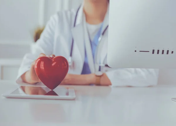 Ärztin mit Stethoskop, das Herz hält, auf hellem Hintergrund — Stockfoto