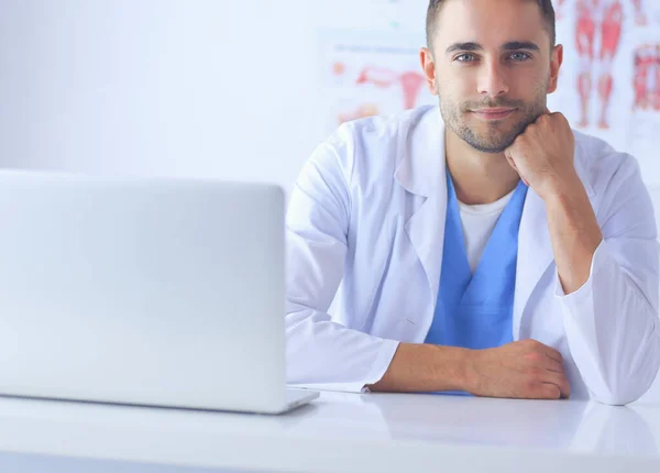 Retrato médico masculino joven y confiado de pie en el consultorio médico. — Foto de Stock