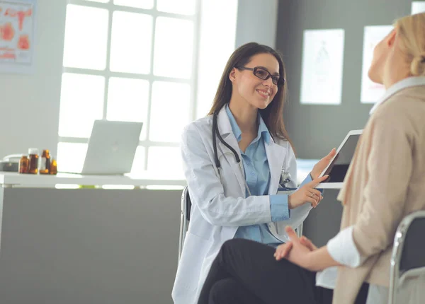 Médico e paciente discutindo algo enquanto se senta na mesa. Conceito de medicina e cuidados de saúde — Fotografia de Stock