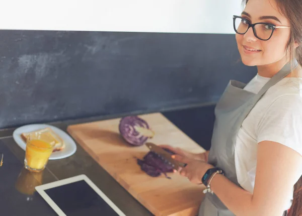 タブレットを使って台所で料理をする若い女性 — ストック写真