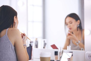 Genç kadın ruj bir ayna önünde uygulama