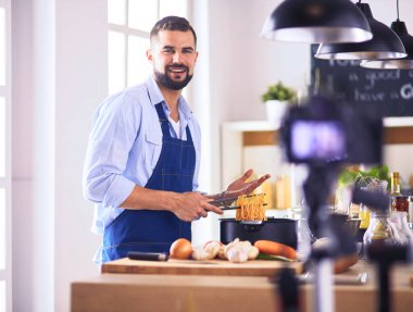 Adam ev mutfağında lezzetli ve sağlıklı yemekler hazırlıyor.