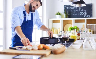 Adam ev mutfağında lezzetli ve sağlıklı yemekler hazırlıyor.