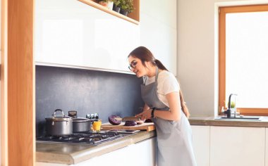 Güzel kadın, ev mutfağında lezzetli ve sağlıklı yemekler yiyor.