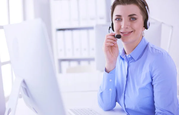 Ernstige mooie jonge vrouw die werkt als support telefoon operator met headset in het kantoor — Stockfoto