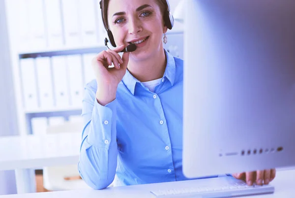 Vážná hezká mladá žena pracující jako podpora telefonního operátora se sluchátky v kanceláři — Stock fotografie