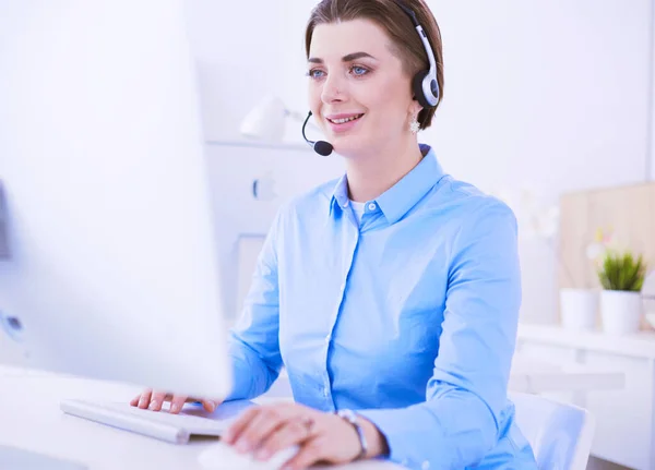 Serious pretty young woman working as support phone operator with headset in office — Stock Photo, Image