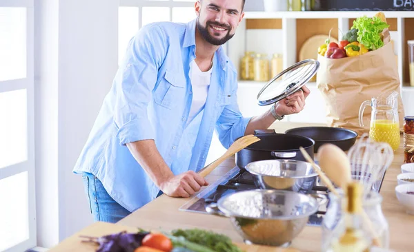 Dijital tablet ve yemek pişirme tarifine uyan bir adam evdeki mutfakta lezzetli ve sağlıklı yemekler pişiriyor. — Stok fotoğraf