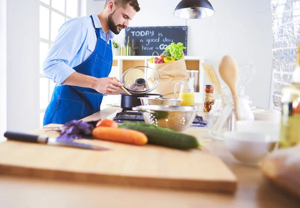 Uomo che prepara cibo delizioso e sano nella cucina di casa — Foto Stock