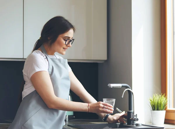 Jonge vrouw gebruikt tablet terwijl ontspannen thuis met koffie op de bank — Stockfoto