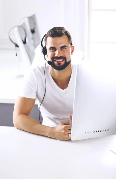 Zakenman in het kantoor aan de telefoon met headset, Skype — Stockfoto