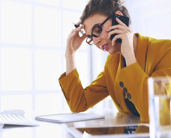 Donna d'affari che si concentra sul lavoro, utilizzando il computer e il cellulare in ufficio — Foto Stock