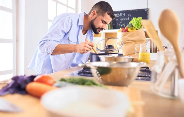 家のキッチンでおいしいと健康食品を準備する男 — ストック写真